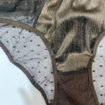 جزئیات تور بدن‌نما با طرح خالدار و دوخت تمیز روی شورت زنانه برنزی