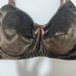 نمای نزدیک بافت لمه کبریتی و درخشش پارچه برنزی سوتین به همراه پاپیون تزئینی