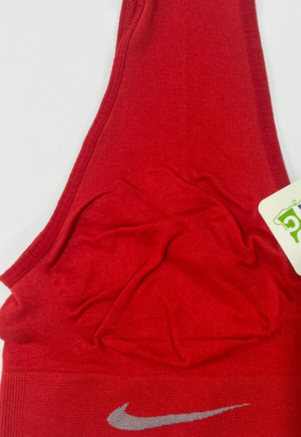 نمای نزدیک لوگوی نایک و بافت کبریتی نیم‌تنه ورزشی زنانه