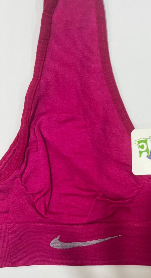 نمای نزدیک لوگوی نایک و بافت کبریتی نیم‌تنه ورزشی زنانه