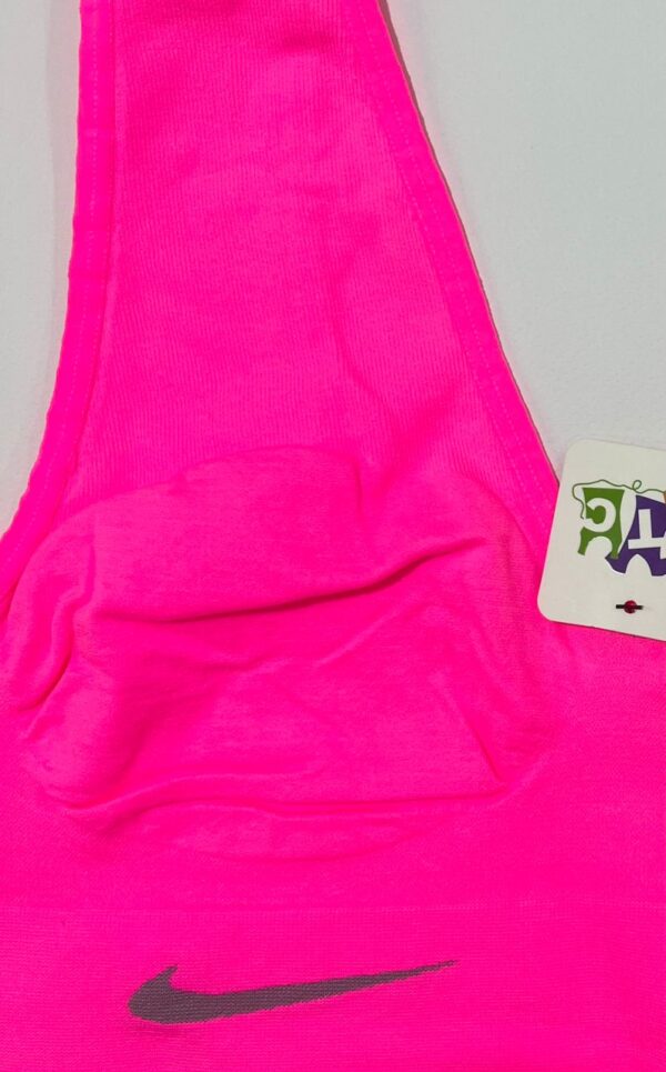 نمای نزدیک لوگوی نایک و بافت کبریتی نیم‌تنه ورزشی زنانه