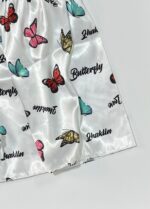 جزئیات چاپ پروانه‌های رنگی و نوشته روی پارچه ساتن لباس خواب فانتزی