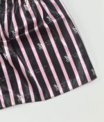 نمای نزدیک پارچه ساتن راه‌راه مشکی و صورتی با لوگوی طرح ویکتوریا سیکرت روی لباس خواب